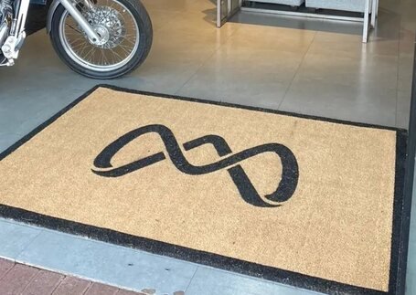 Capachos de Fibra de Coco para entrada comercial com identidade visual personalizada em imagem de referência da Real Tapetes