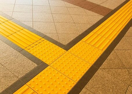 Piso tátil com placas de alerta em imagem de referência da Real Tapetes