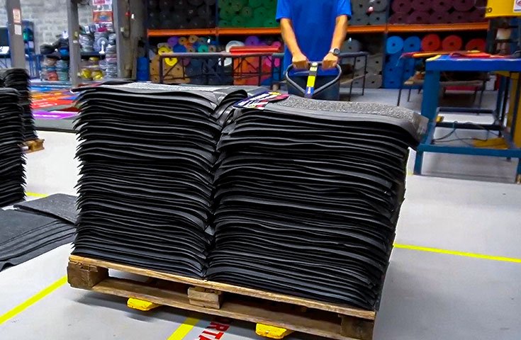Interior da fábrica da Real Tapetes com tapetes e capachos prontos para entrega